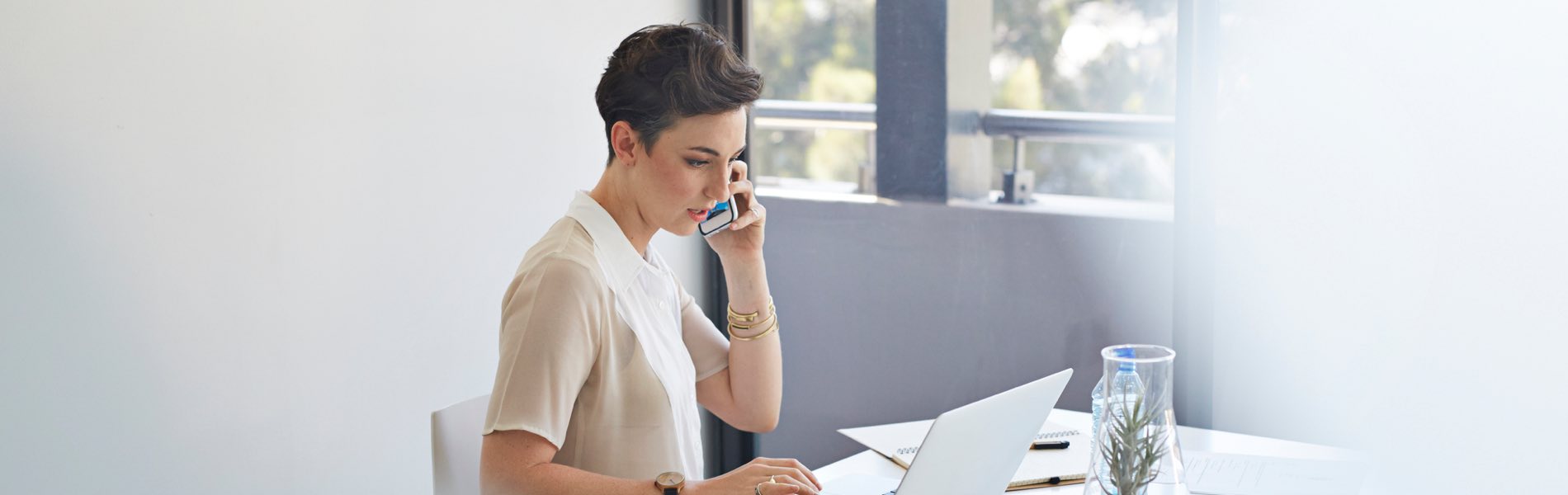 women on phone using laptop