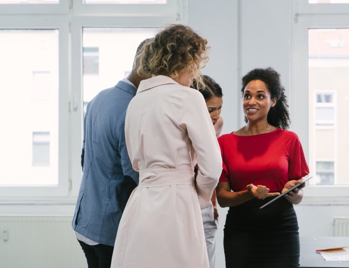 business team with woman pointing to contract management utility data on tablet