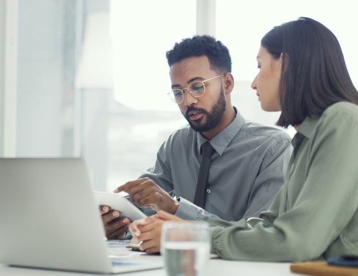 two business people looking at tablet discussing utility expense recovery