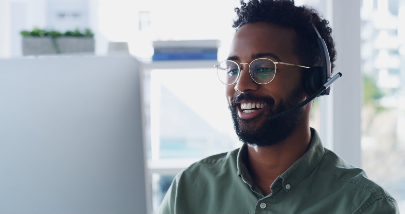 man with headset talking in front of computer