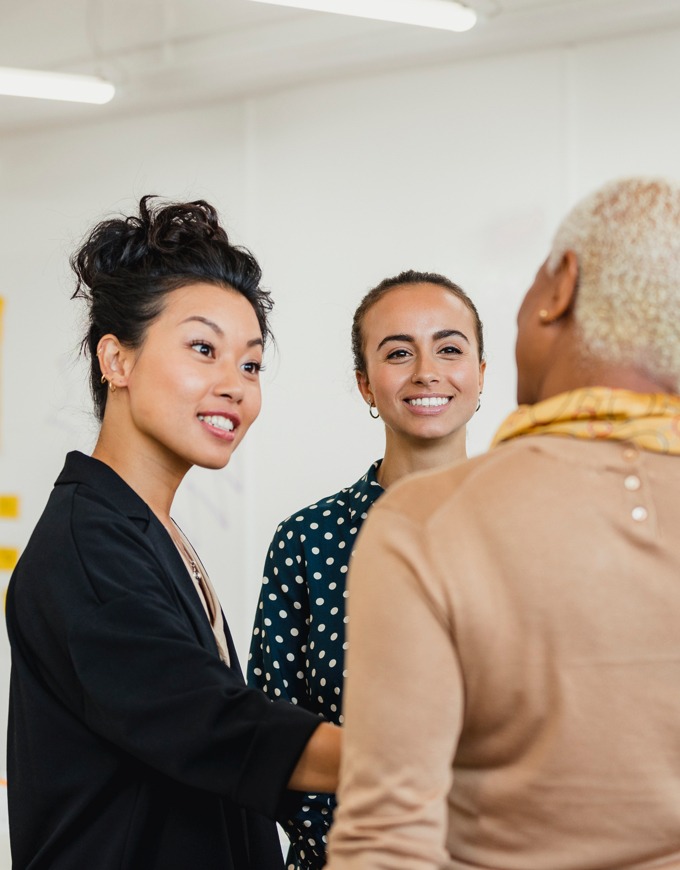 women meeting shaking hands and smiling