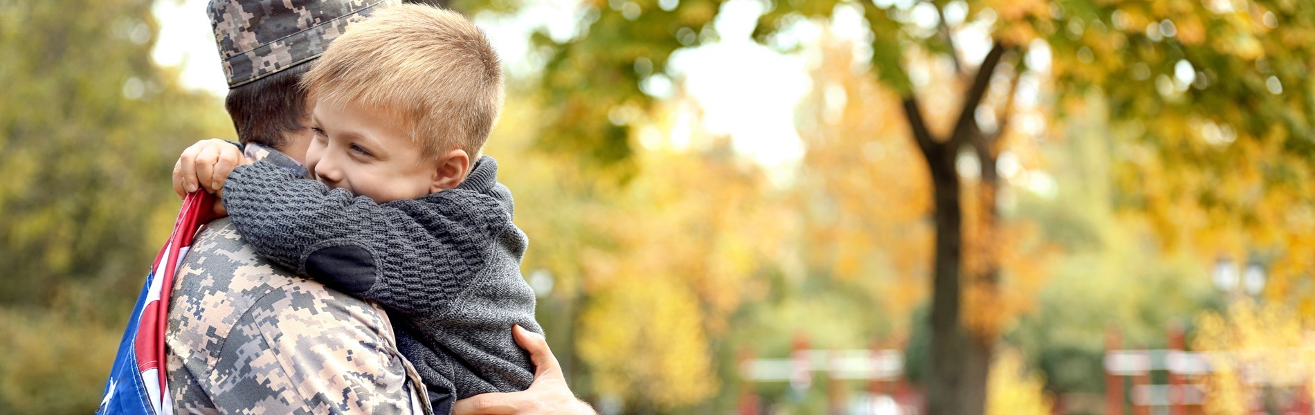 boy hugging military family member