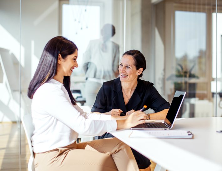 2 businesswomen laughing and working