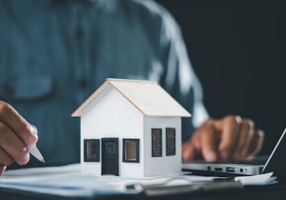 Real estate contract property mortgage finance signing approved, home buying document homeowner house tenant investment insurance involves person signing document near house model, laptop.